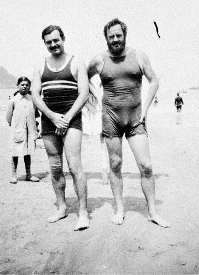 A photo of Ernest Hemingway and Waldo Peirce standing on the beach in San Sebastian in their swimsuits.